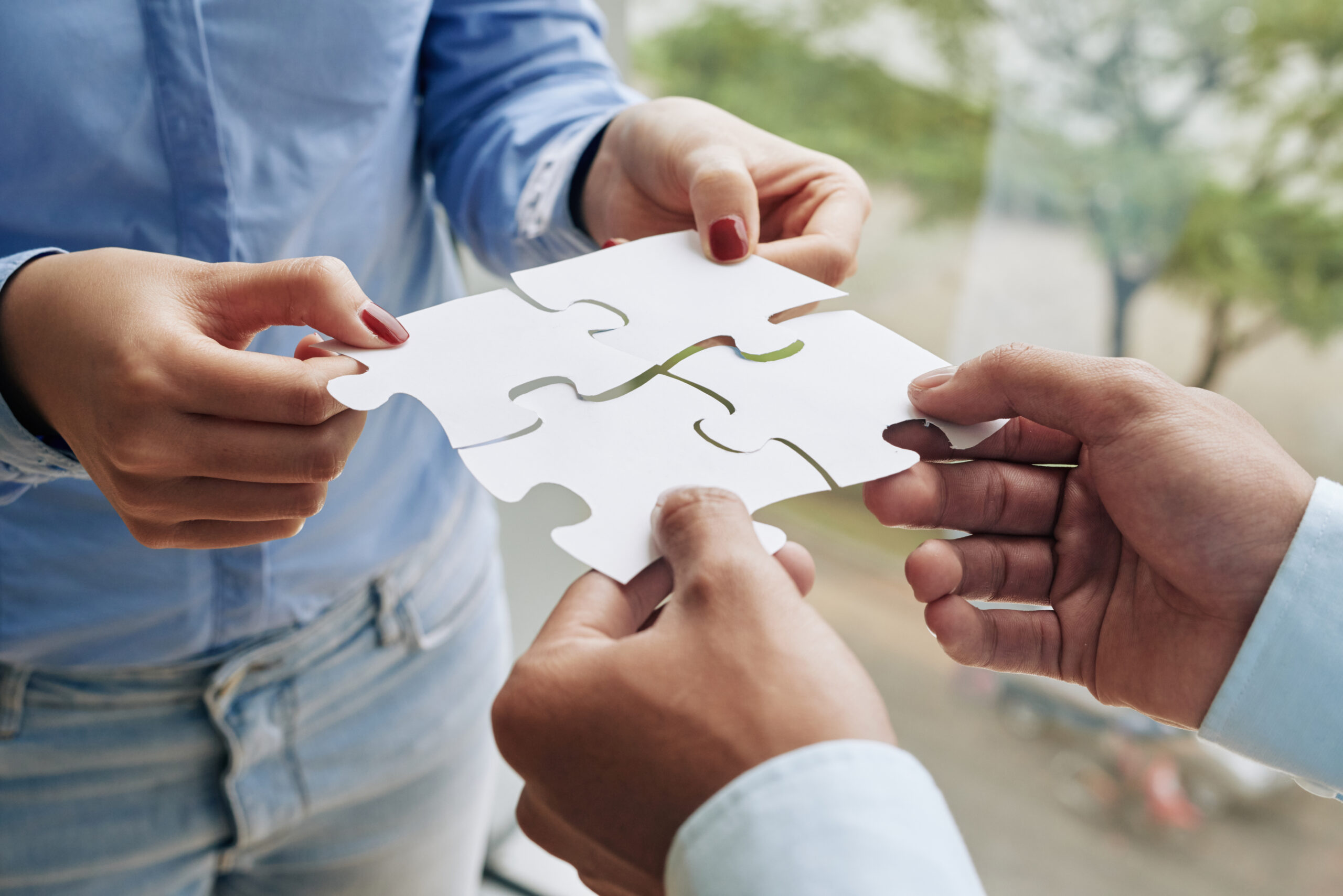 Close-up image of business people assembling puzzle